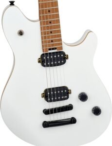 EVH Wolfgang Standard hardtail guitar in Cream White resting on a worn leather couch with a black strap attached